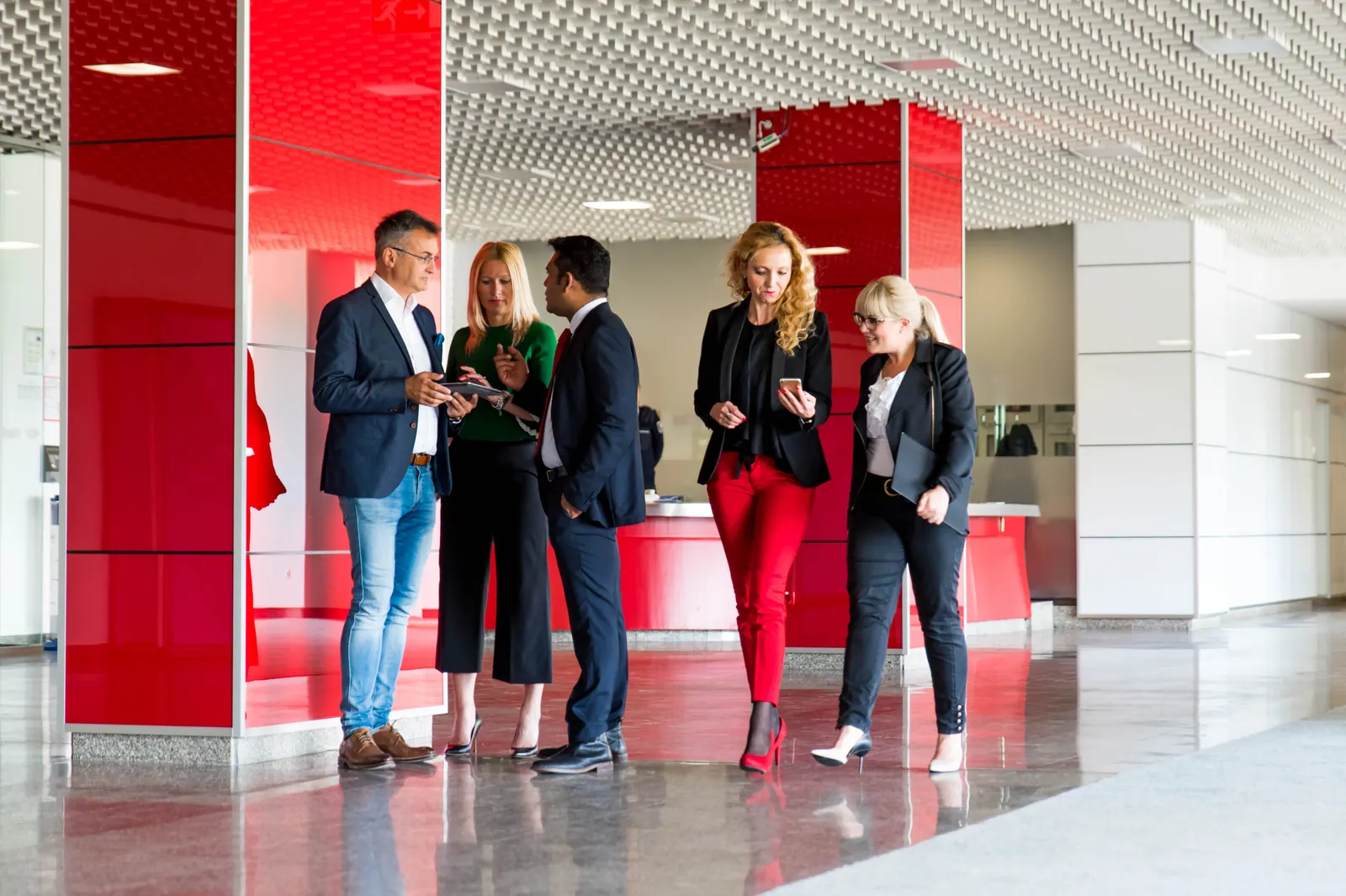 Business colleagues talking in a red and white building interior