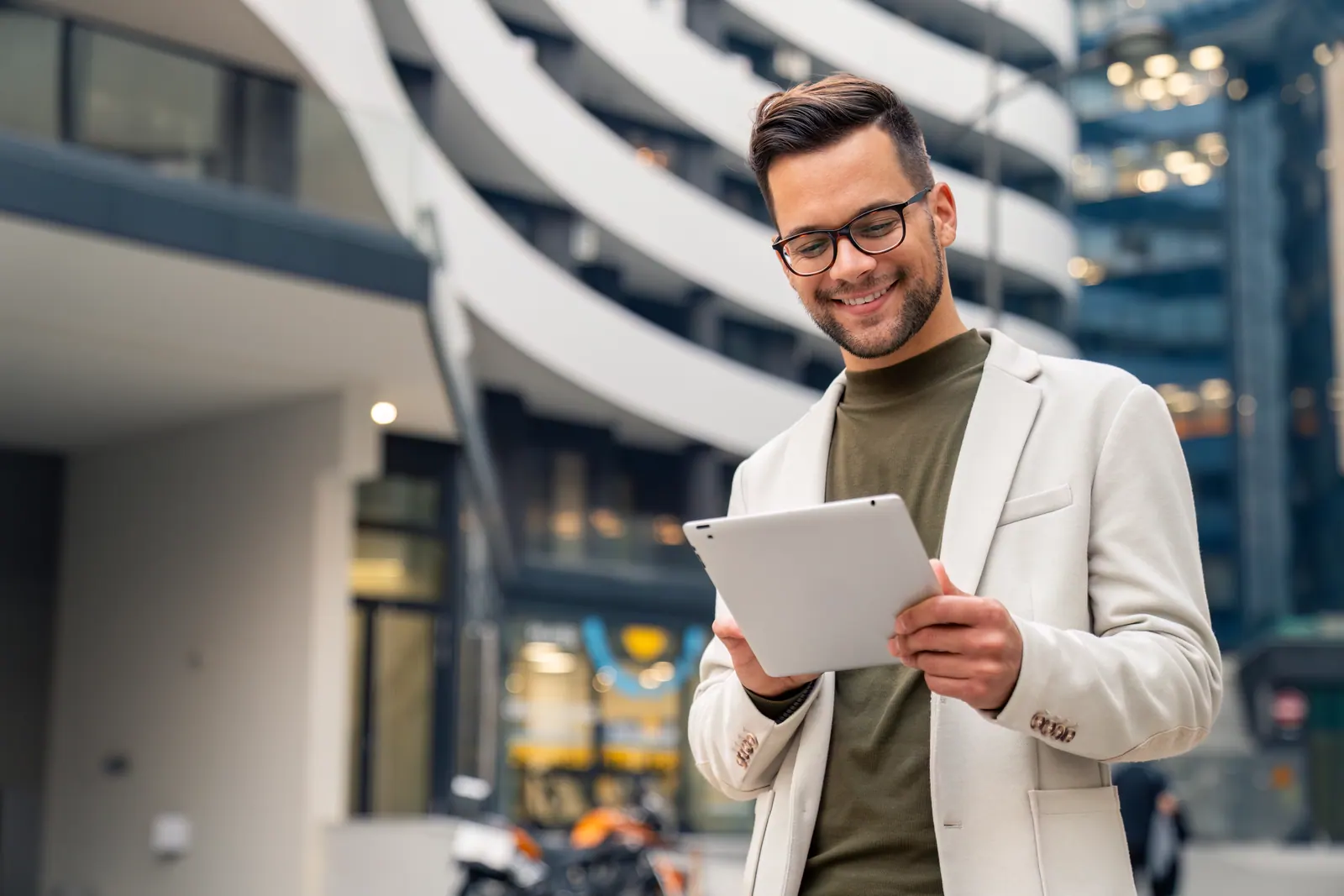 Business professional using a tablet outside a modern building while planning a web application
