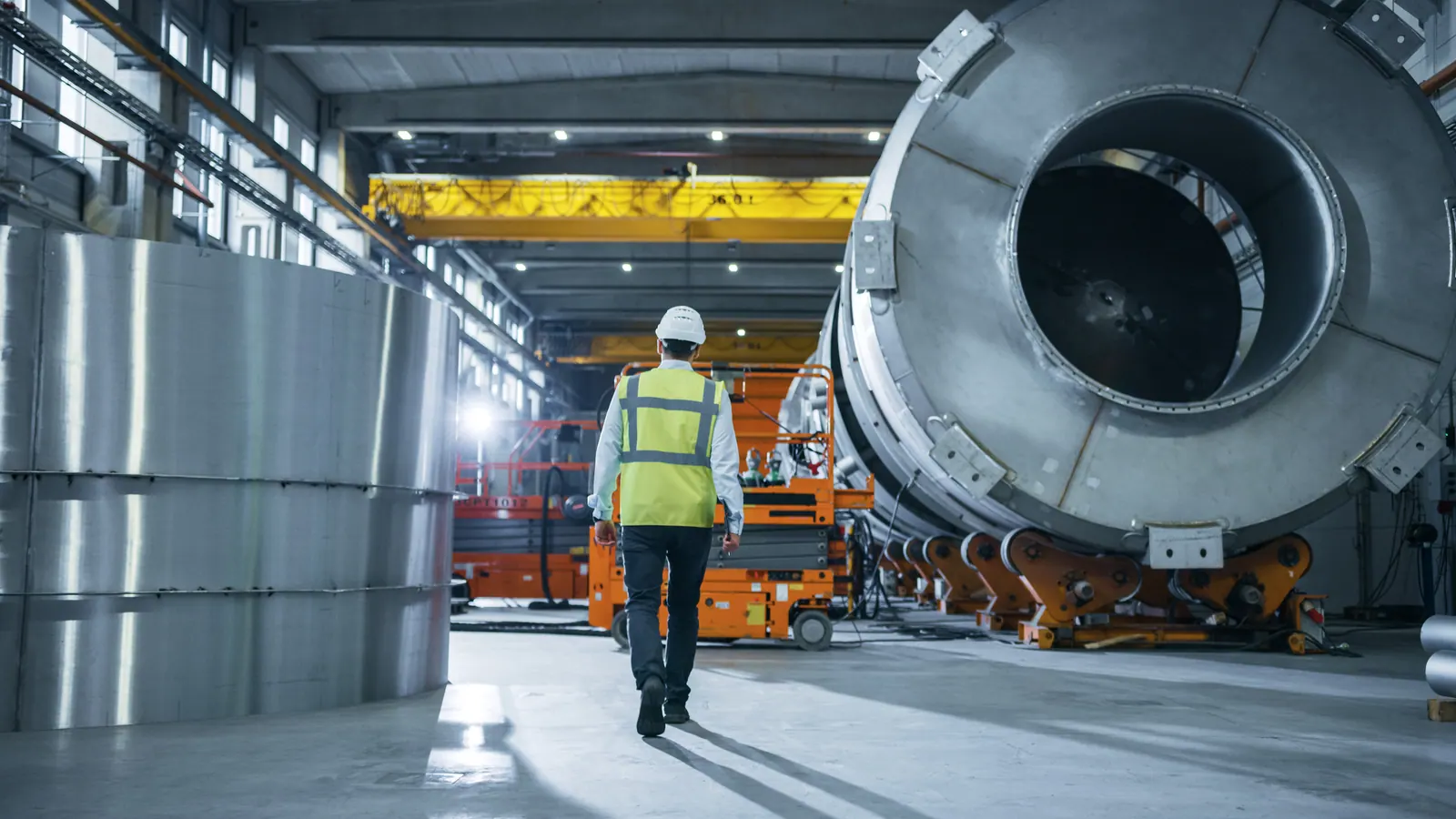 Workers inspecting large machinery on a factory floor